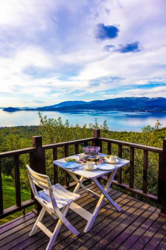 a table and chairs on a deck with a view of the water at Kiraz Sunset Bungalow Famıly in Bandırma