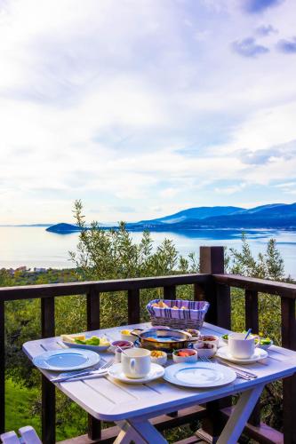 una mesa de picnic con comida en el balcón con vistas al agua en Kiraz Sunset Bungalow Famıly, en Bandırma