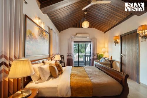 a bedroom with a large bed with a wooden ceiling at StayVista's Grace & Light - Hill-view villa with Outdoor pool, Terrace & Games room in Panchgani