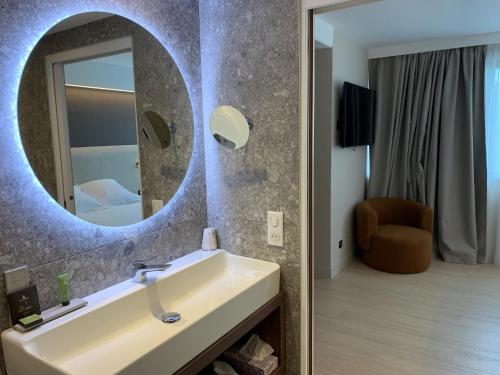 a bathroom with a sink and a mirror at Best Western Plus Metz Technopole in Metz