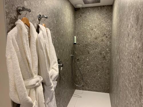 a bathroom with white towels hanging on a wall at Best Western Plus Metz Technopole in Metz