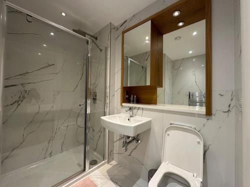 a bathroom with a sink and a shower and a toilet at Hanger Lane Luxury Apartment in Perivale