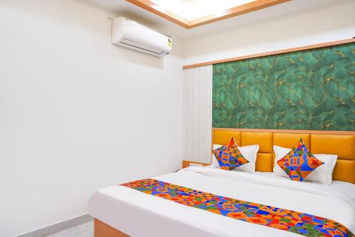 a bedroom with two beds and a painting on the wall at FabHotel Lotus Blue in Bhopal