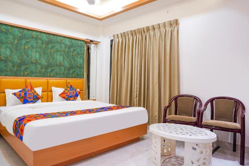 a bedroom with a bed and two chairs at FabHotel Lotus Blue in Bhopal