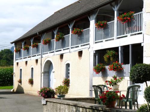 un bâtiment avec des boîtes de fleurs sur les fenêtres dans l'établissement Maison Palu, à Asson