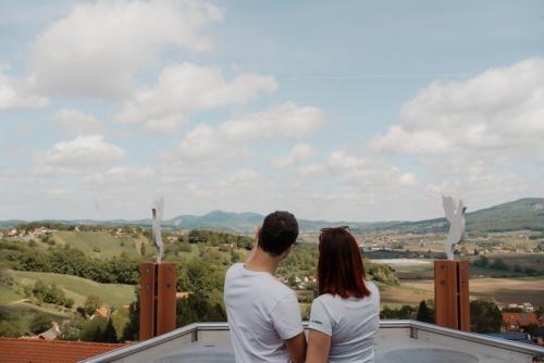 a man and a woman sitting on top of a building at De Merin Boutique Hotel Straden in Straden