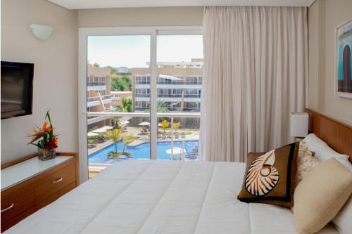 a hotel room with a large bed and a balcony at Hotel Margarita Real in Pampatar