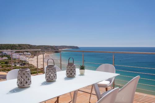 a white table with chairs and a view of the ocean at Villa Mar a Vista in Salema