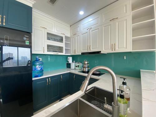 uma cozinha com armários verdes e brancos e um lavatório em Mikage - Vinhome D'capitale - Tran Duy Hung - Hanoi em Hanói