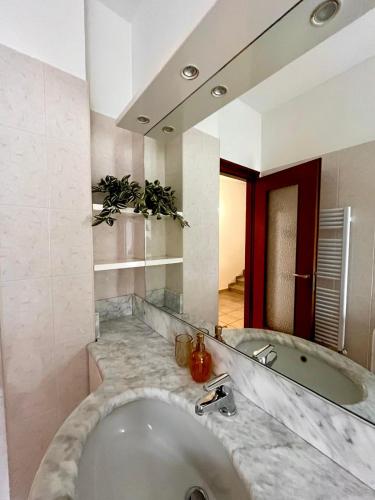 een badkamer met een groot bad en een wastafel bij Perla house in Abbadia Lariana