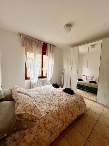 een slaapkamer met een groot bed en een grote spiegel bij Perla house in Abbadia Lariana