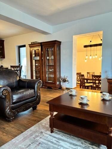 uma sala de estar com um sofá de couro e uma mesa de centro em Casa Mara em Cristian