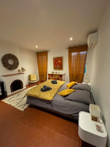 a bedroom with a large bed and a fireplace at Maison de village rénovée avec vue mer exceptionnelle in Sainte-Maxime