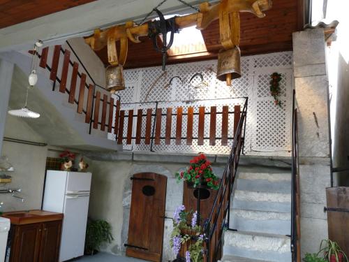 a kitchen and stairs in a house with flowers at Maison Palu in Asson
