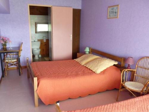 ein Schlafzimmer mit einem Bett, einem Tisch und einem Stuhl in der Unterkunft Maison Palu in Asson