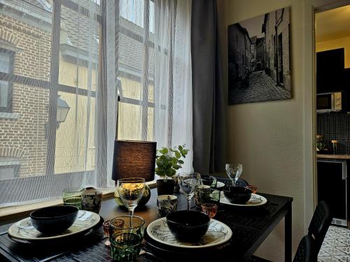 stół jadalny z talerzami i okularami oraz okno w obiekcie Begijnhof Historica Tongeren w mieście Tongeren