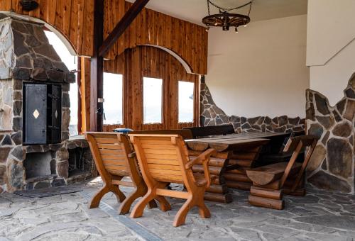 a table and chairs in a room with a stone fireplace at Pokoje u Chmielaków - Huba in Maniowy