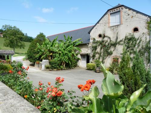 Un bâtiment avec un bouquet de fleurs devant lui dans l'établissement Maison Palu, à Asson