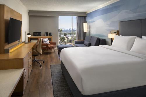 una camera d'albergo con un grande letto e una TV di Courtyard by Marriott Long Beach Downtown a Long Beach