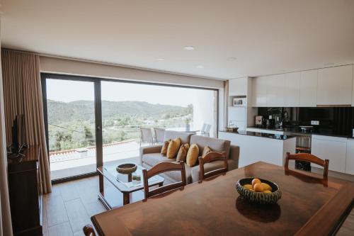 a kitchen and a living room with a table at Quinta da Nascente in Soutelo