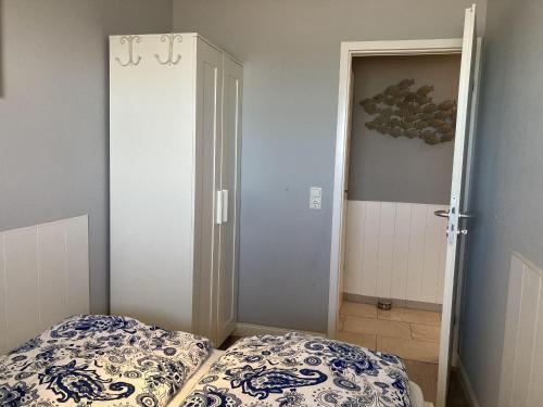 a bedroom with a bed and a door to a closet at Strandhotel-Superblick-60 in Dahme