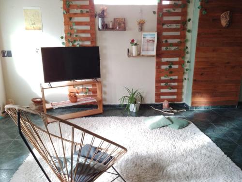 uma sala de estar com uma televisão de ecrã plano na parede em Como en Casa em Comodoro Rivadavia