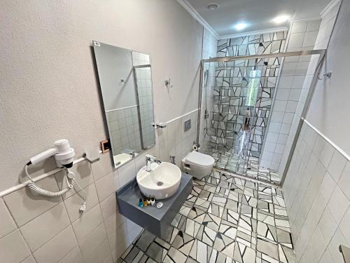 y baño con aseo, lavabo y espejo. en Arena Sport Hotel en Quba