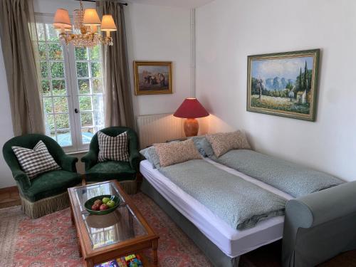 a living room with a bed and a table at La Maison du Gardien, Chateau de lAvenue in Pierrefitte-en-Auge