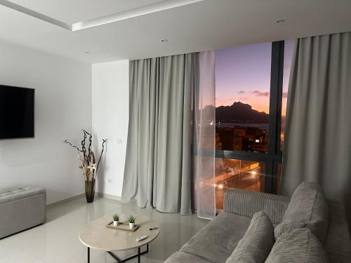 a living room with a couch and a table at Sharksproperties Apartment in Mindelo