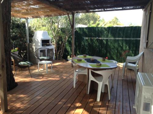 un patio avec une table, des chaises et un barbecue dans l'établissement Le Pin Parasol, à Porto-Vecchio
