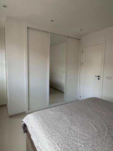 a bedroom with white cabinets and a large mirror at Sharksproperties Apartment in Mindelo