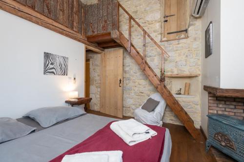une chambre avec un grand lit et un escalier dans l'établissement MAs en pierre 17ème piscine exposition sud proche uzès, à Aubussargues