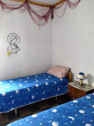 a bedroom with two beds with blue sheets and a table at nuovi appartamenti dai pescatori in Savelletri di Fasano