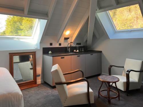 a attic room with a sink and a table and chairs at La Villa du Lac in Aiguebelette-le-Lac