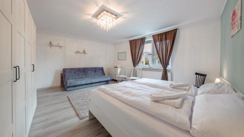 1 dormitorio con 1 cama y 1 sofá azul en Apartamenty Sun & Snow Wojska Polskiego Puck en Puck