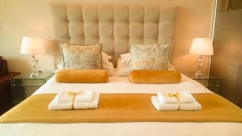 1 dormitorio con 1 cama con toallas en Menlyn Maine Residences - Central Park with king sized bed, en Pretoria