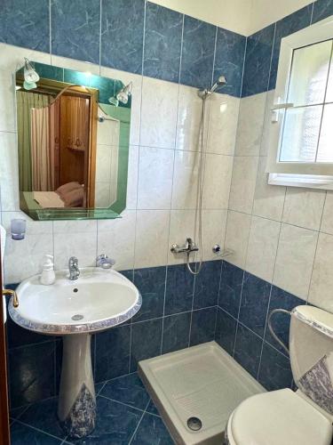 a bathroom with a sink and a toilet and a mirror at Levi's Villa Radhima in Vlorë