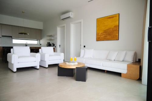 a living room with two white couches and a table at Ashta Gold Suite in Fethiye
