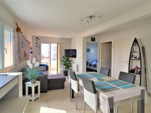 une salle à manger et un salon avec une table et des chaises dans l'établissement Bel appartement au centre de Royan avec balcon, garage et ascenseur - FR-1-494-188, à Royan