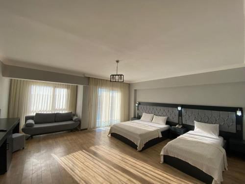 Habitación de hotel con 2 camas y sofá en Carpediem Diamond Hotel, en Karasu