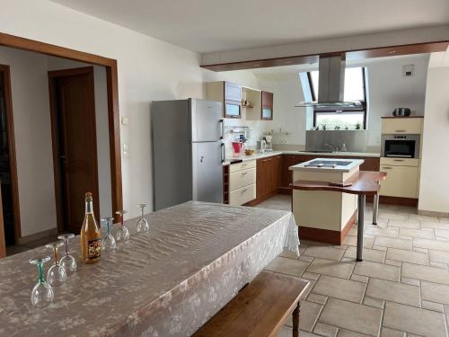 - une cuisine avec une table avec des bouteilles et des verres dans l'établissement Maison 6 personnes Saint Cast Le Guildo, à La Garde
