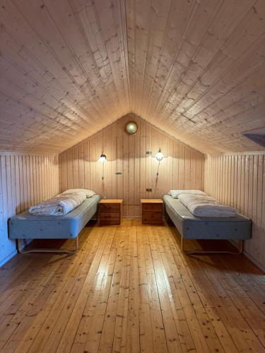 two beds in a room with a wooden floor at Tyinkrysset panorama in Tyinkrysset