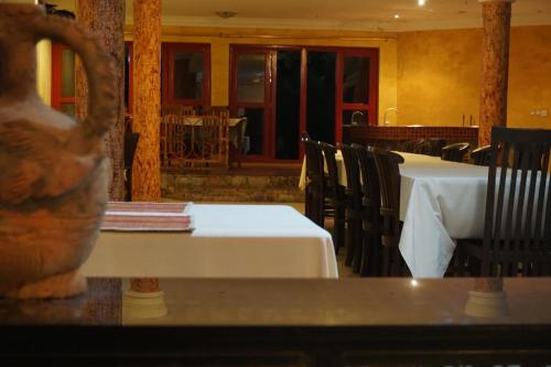 a dining room with tables and chairs and a vase at Accra Royal Castle Apartments & Suites in Kwabenya