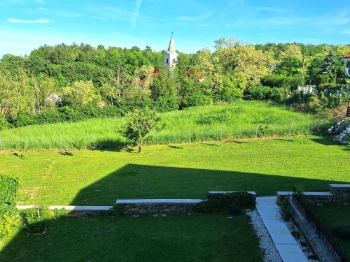 a garden with a church in the middle of a field at Holling apartman in Fertőboz