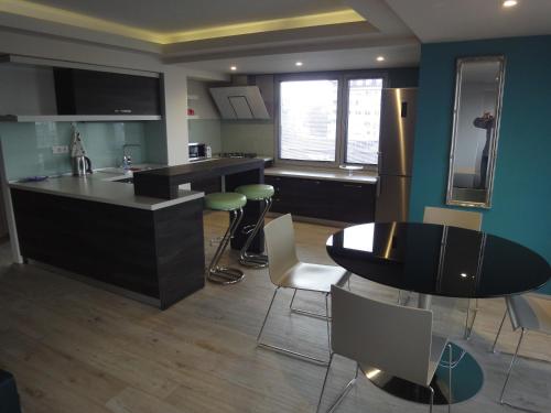 a kitchen with a counter and a table and chairs at Joan Apartments & Spa in Skopje