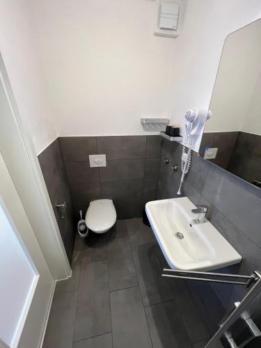 a bathroom with a white toilet and a sink at Ferienwohnungen und Appartements - Haus Budinger in Alf