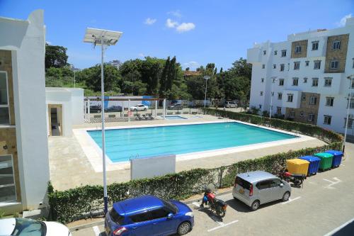una piscina en un aparcamiento junto a un edificio en Noli holiday homes Buxton Point Mombasa en Mombasa