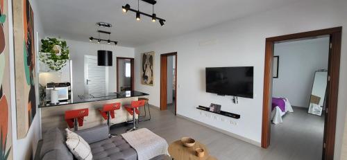 een woonkamer met een bank en rode stoelen bij Villa Terranova in Mozaga