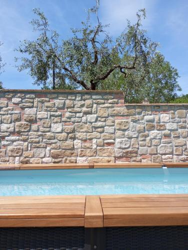 een stenen muur met een bank ervoor bij OLEA casa vacanze in Todi