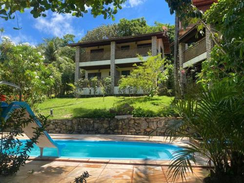 una casa con piscina frente a una casa en Pousada Barracuda Pipa, en Pipa